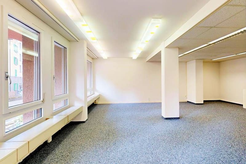 empty room with windows, gray floor, white walls, four columns, long bench