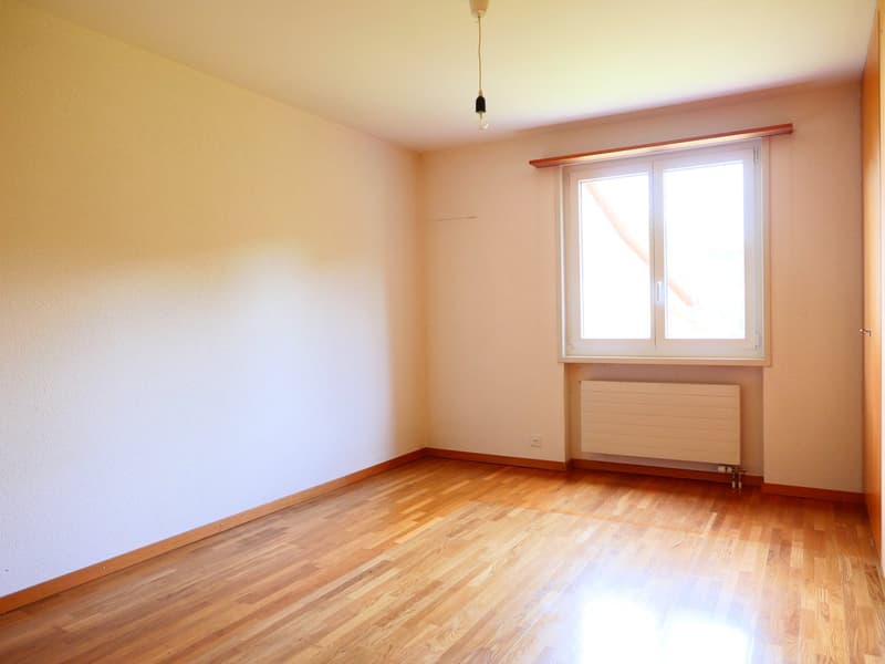 white walls, wooden floor, large window, radiator