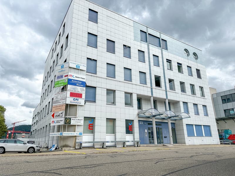 white building, multiple windows, multiple signs, parking lot, benches, entrance