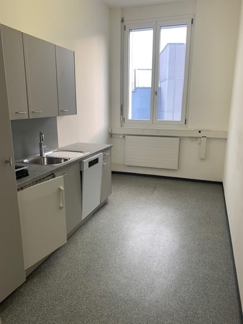 empty kitchen with appliances, cabinets, countertop and sink