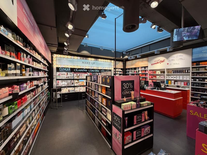Cosmetics store with various products on shelves, a central display, and a sales counter.