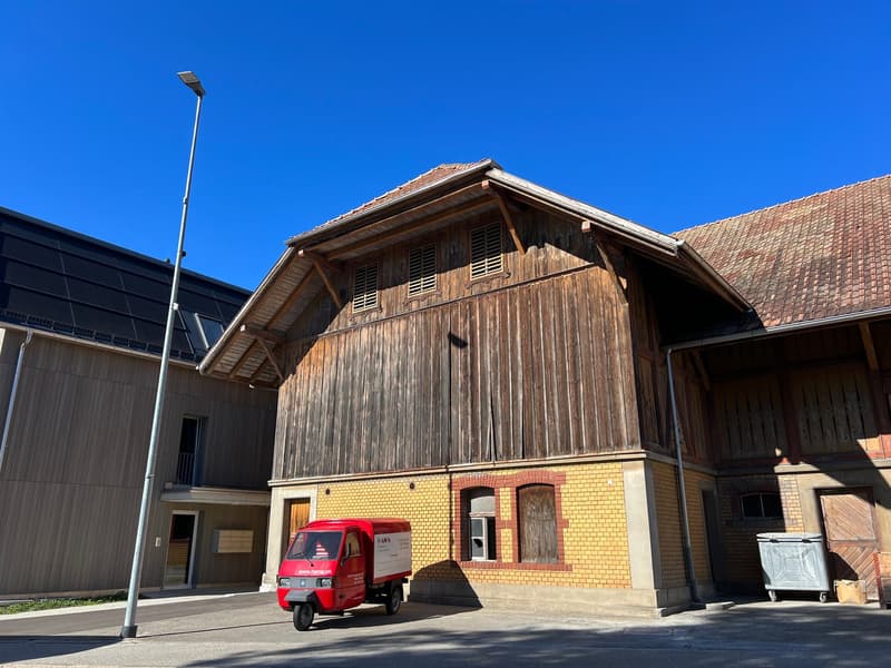 Large wooden house, yellow brick base, large windows, red roof, driveway, delivery vehicle