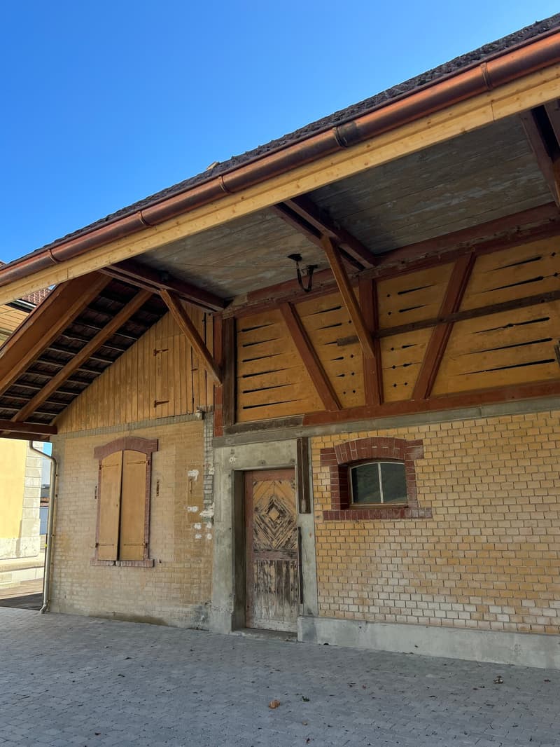 Single story brick house with wooden roof beams, wooden shutters, wooden door
