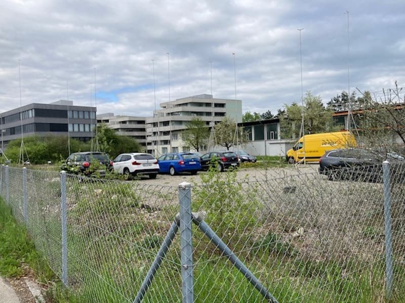 Parking lot with cars and buildings in background