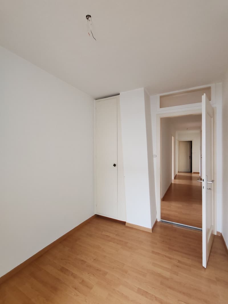 empty room with two doors leading to the hallway, wooden floor, white walls