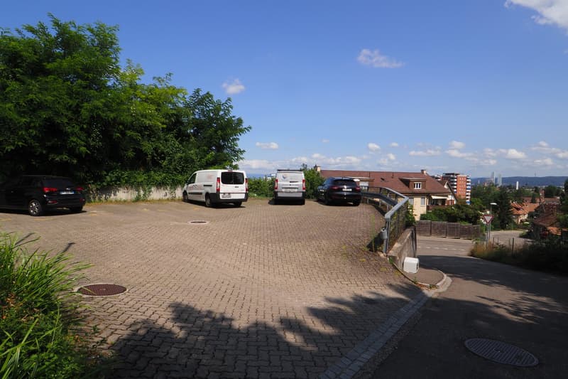 4 cars parked in parking area, metal railings, brick paved floor, greenery