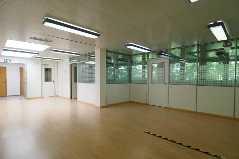 Floor room with large windows, wooden floor, bright lights, glass partitions