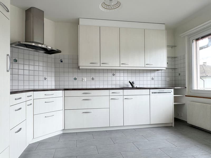 modern kitchen with white cabinets, tiled backsplash, stainless steel range hood, dishwasher, granite countertops, gray flooring