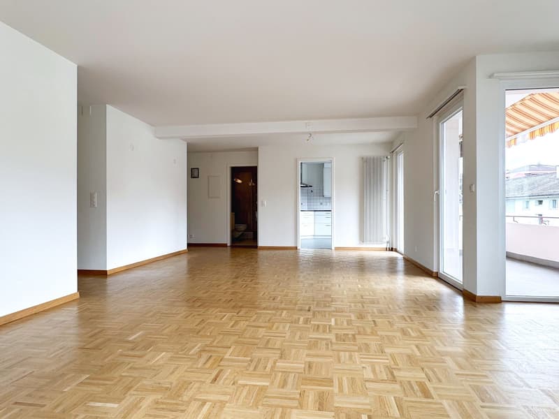 empty room, wooden parquet floor, white walls, sliding glass doors, balcony