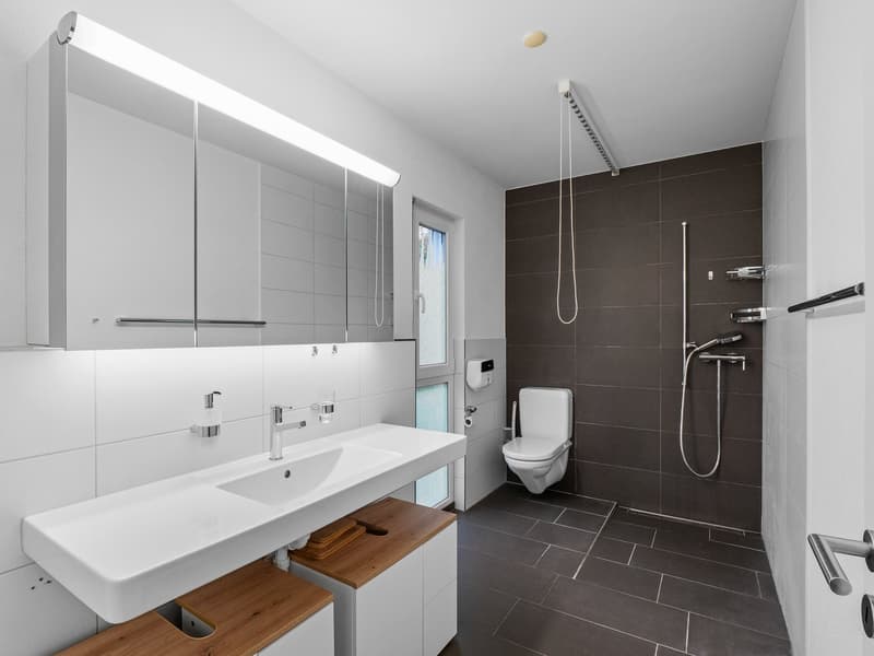 modern design, white sink, grey tiled walls, large mirror, white toilet
