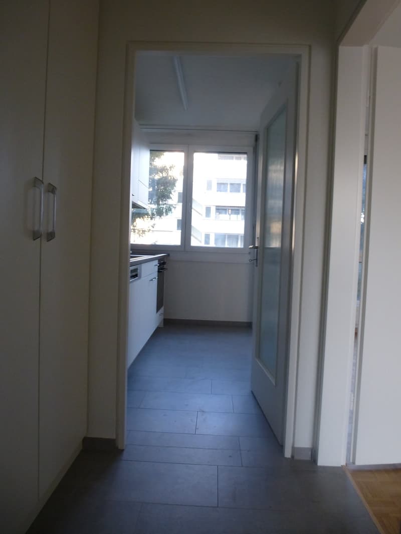 empty room, white cabinets, open doors, window with view, tiled floor