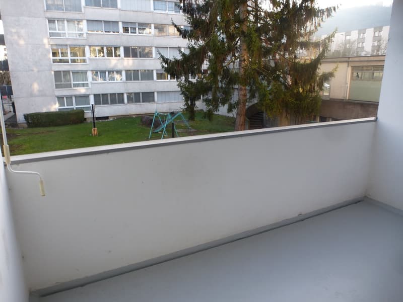 Empty balcony with walls and floor, view to grass and building