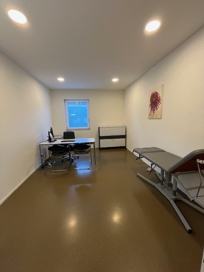 spacious room, desks, two chairs, monitors, cabinets, exam table, large windows
