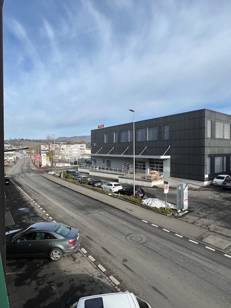 Industrial building on road with parking, street lights