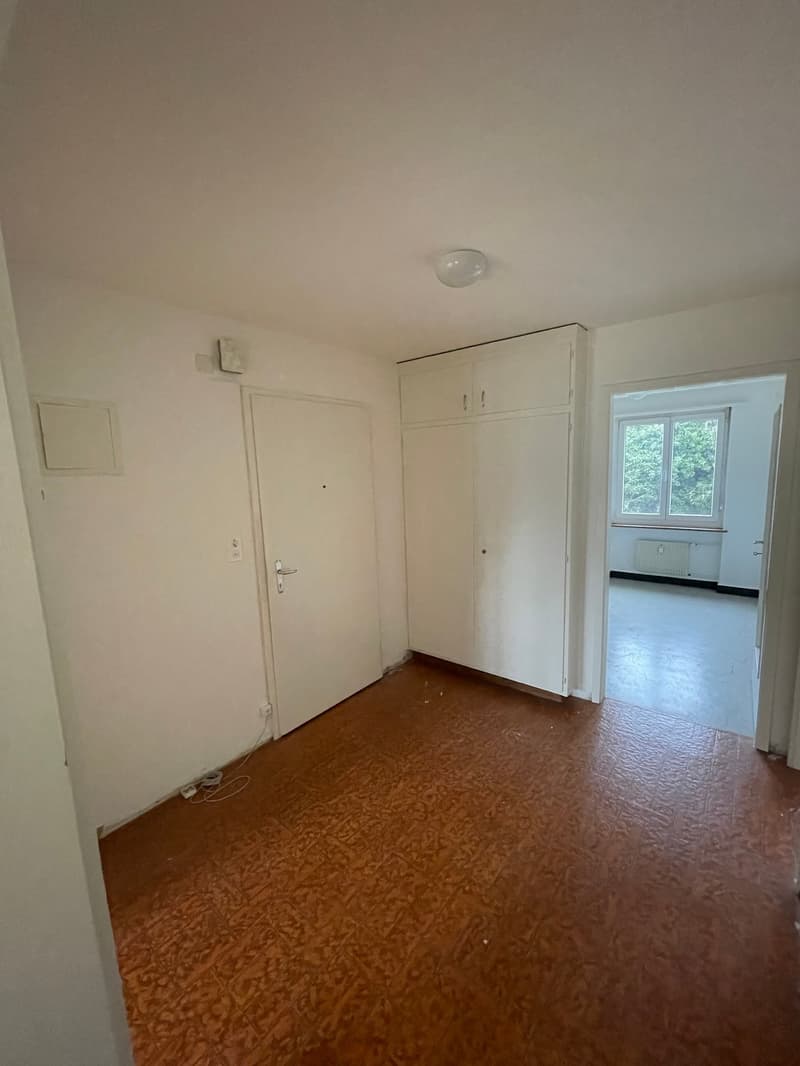 empty room, wooden floor, white walls, white cabinets, window, power outlet