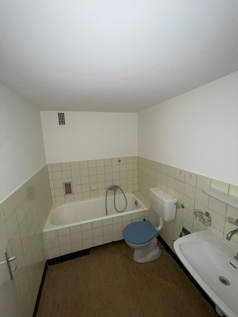 Bathroom with bathtub, toilet, sink, tile flooring, white walls