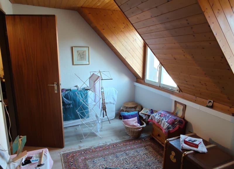 sloping ceilings, wooden interior, rug, baskets, storage boxes, window, picture frames
