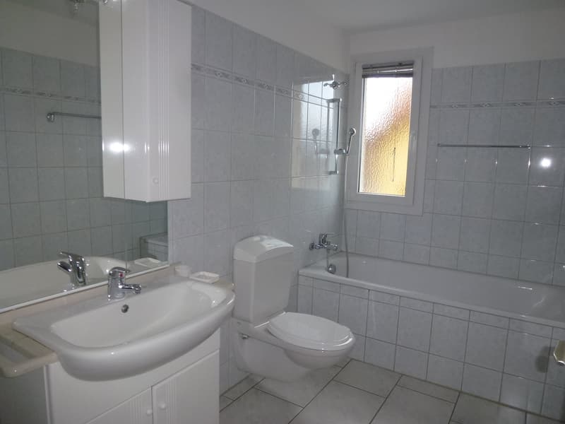 Bathroom with sink, toilet, bathtub, mirror, cabinet, and tiles