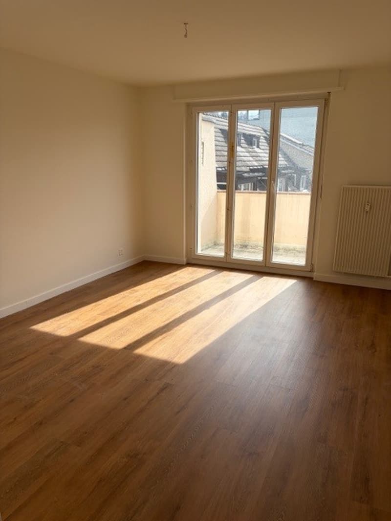 empty room, wooden floor, sliding glass door, balcony, white walls, radiator