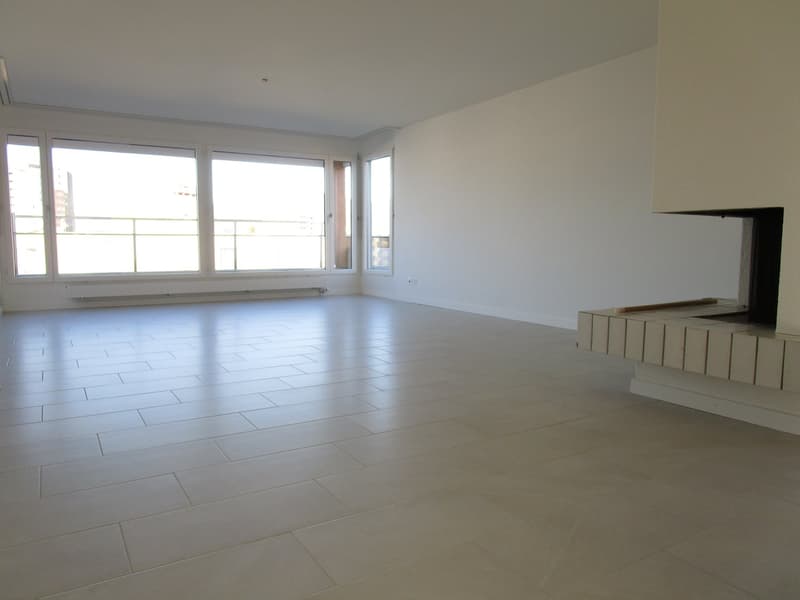 large windows, fireplace, white walls, tile flooring, balcony