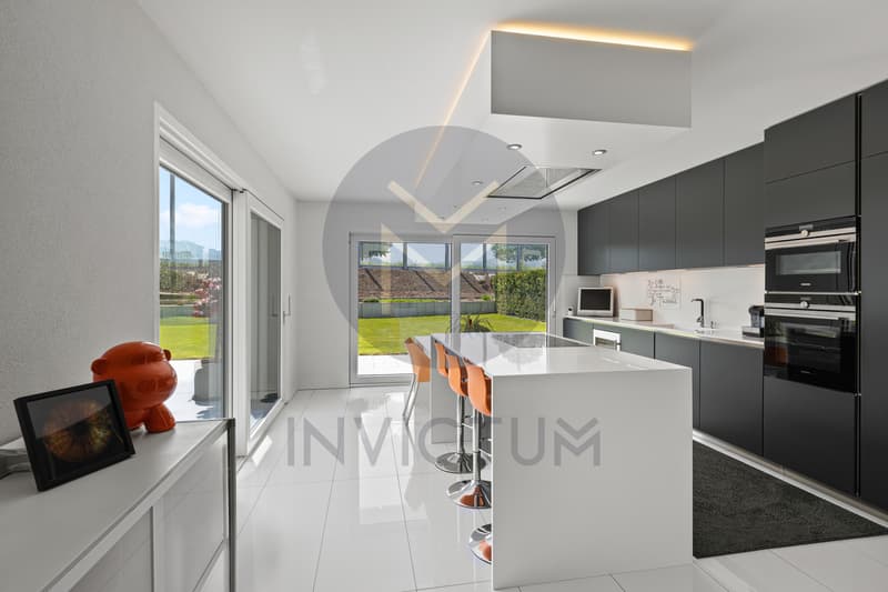 Grande cuisine lumineuse avec îlot central et accès direct au jardin