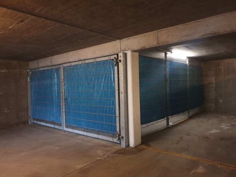 underground parking garage, gated areas, blue metal grates, concrete floor, illuminated ceiling