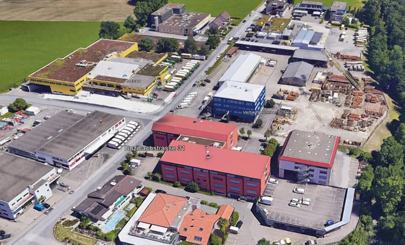 Industrial area with multiple buildings, parking lots, and green spaces