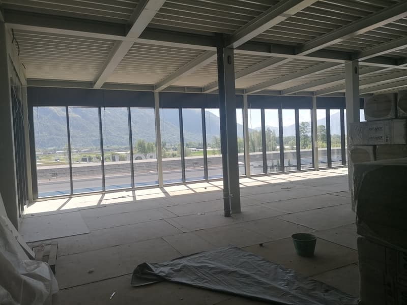 Empty room, large windows, mountains in the distance, construction materials