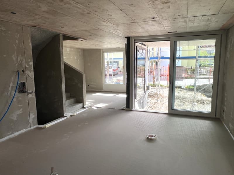 Empty room, concrete floor, unfinished walls, stairs, sliding glass doors, balcony