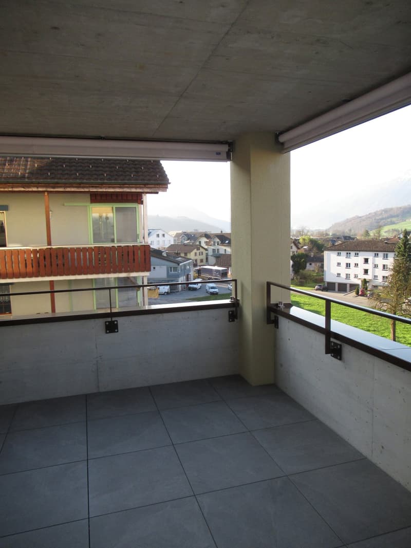 Balcony with tiled floor, metal railings, and a view of the street and mountains
