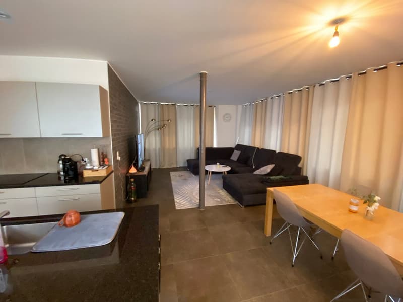Open plan living room and kitchen, modern furniture, large windows, tiled floor, dining table, comfortable seating, kitchen appliances, decorative items