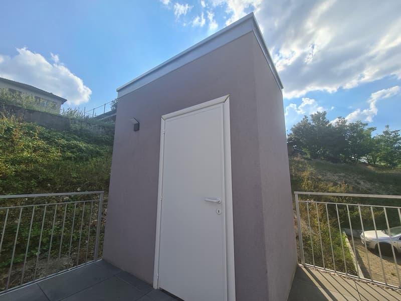 Garage in building, white door, metal railing on balcony