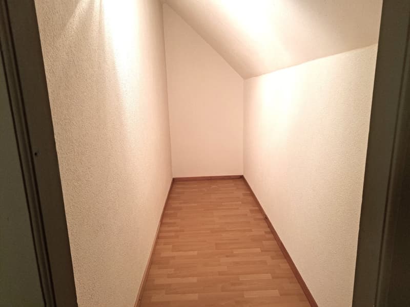 empty room, wooden floor, beige walls, corner of the room visible