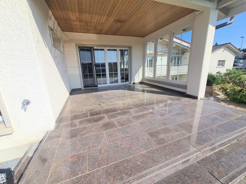 Covered patio with wooden ceiling, large windows, and granite tile flooring