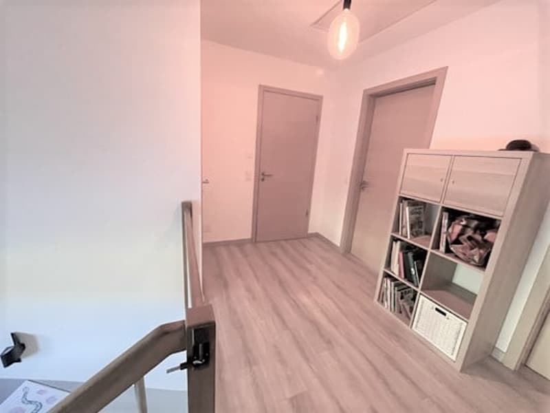 Hardwood flooring, white walls, two doors, a bookshelf unit, and a dishwasher visible in the image.
