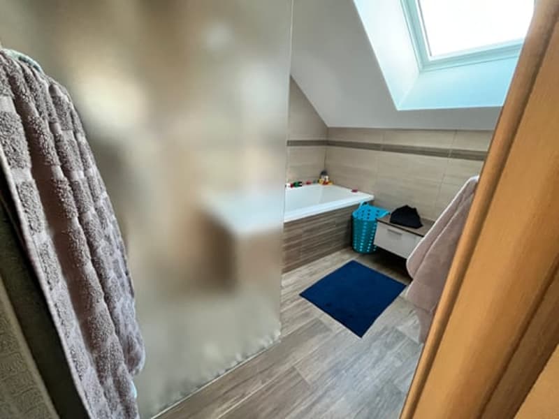Bathroom with tiled floor, skylight, towel rack, and storage space