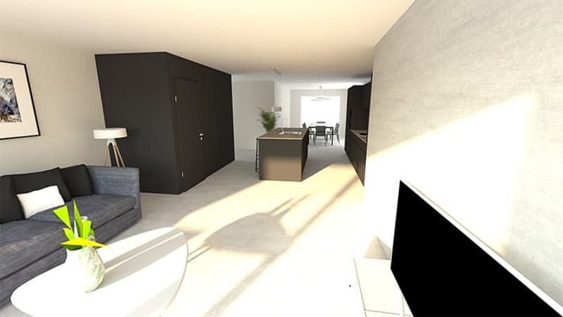open-concept living room with grey sofa, coffee table, and kitchen area visible in the background, large windows allowing natural light to enter the space