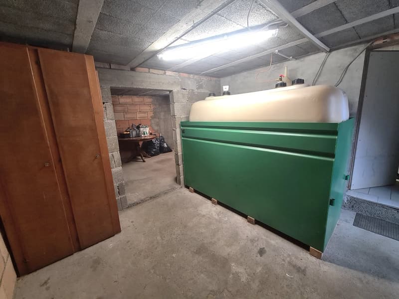 storage room, concrete walls, concrete floor, gas cylinder, wardrobe, wooden door, table with trash bin