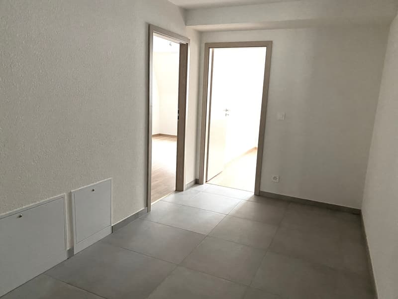 empty room, gray tiled floor, white walls, two doors, power outlet