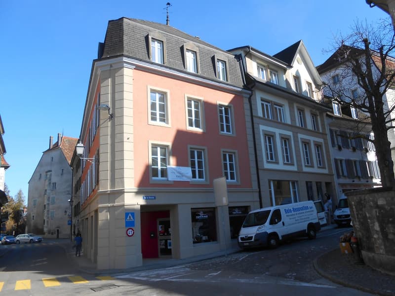 3-story building, red door, multiple windows, parked vans