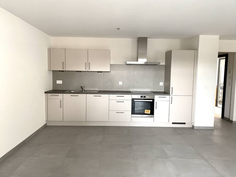 modern kitchen, white cabinetry, black countertop, stainless steel appliances, tiled flooring