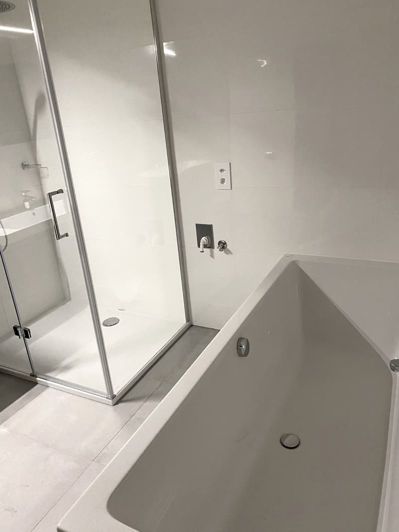 bathroom with a bathtub and a shower with a glass door
