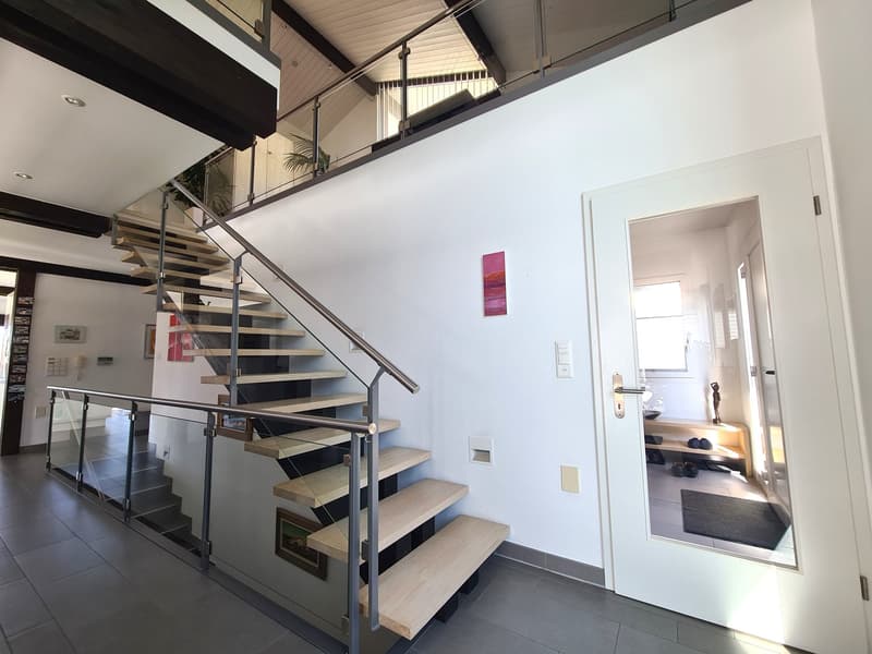 modern design interior with a staircase, glass walls, white walls, tiled floor, open door