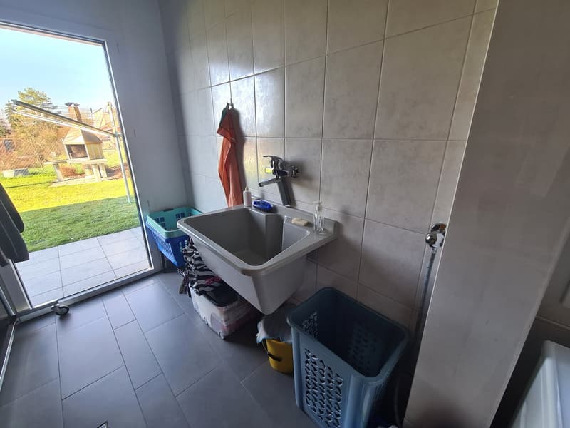 washroom with tile flooring, a white sink with a faucet, and various laundry baskets