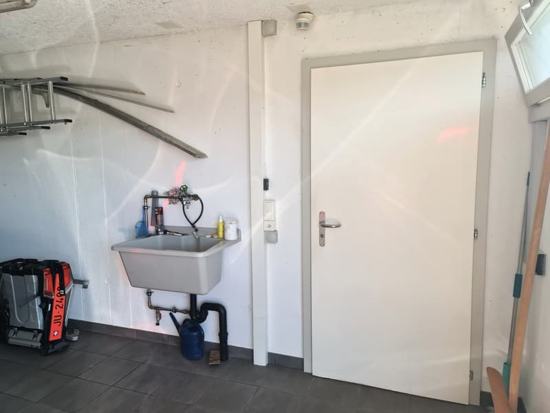Utility room with sink, tile floor, white walls, black piping, ladder