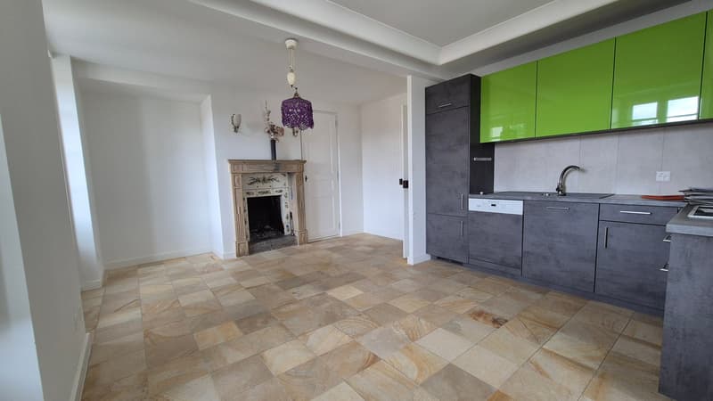 Fireplace, tiled floor, white walls, kitchen with green cabinets, open doorway