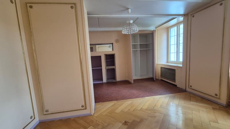 open layout, wooden floor, beige walls, white ceiling, open wardrobe, lamp, radiator, window, mirror