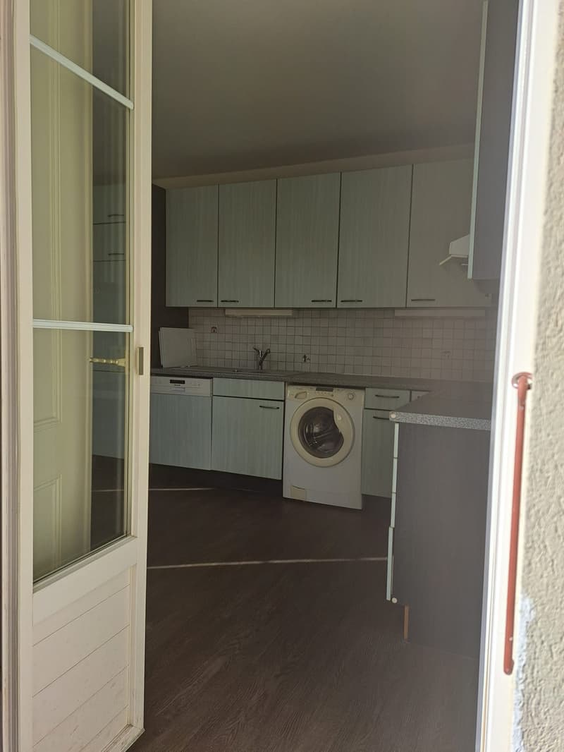 modern kitchen, tiled walls, dishwasher, washing machine, wooden floors, green cabinets, white countertop, sink, faucet
