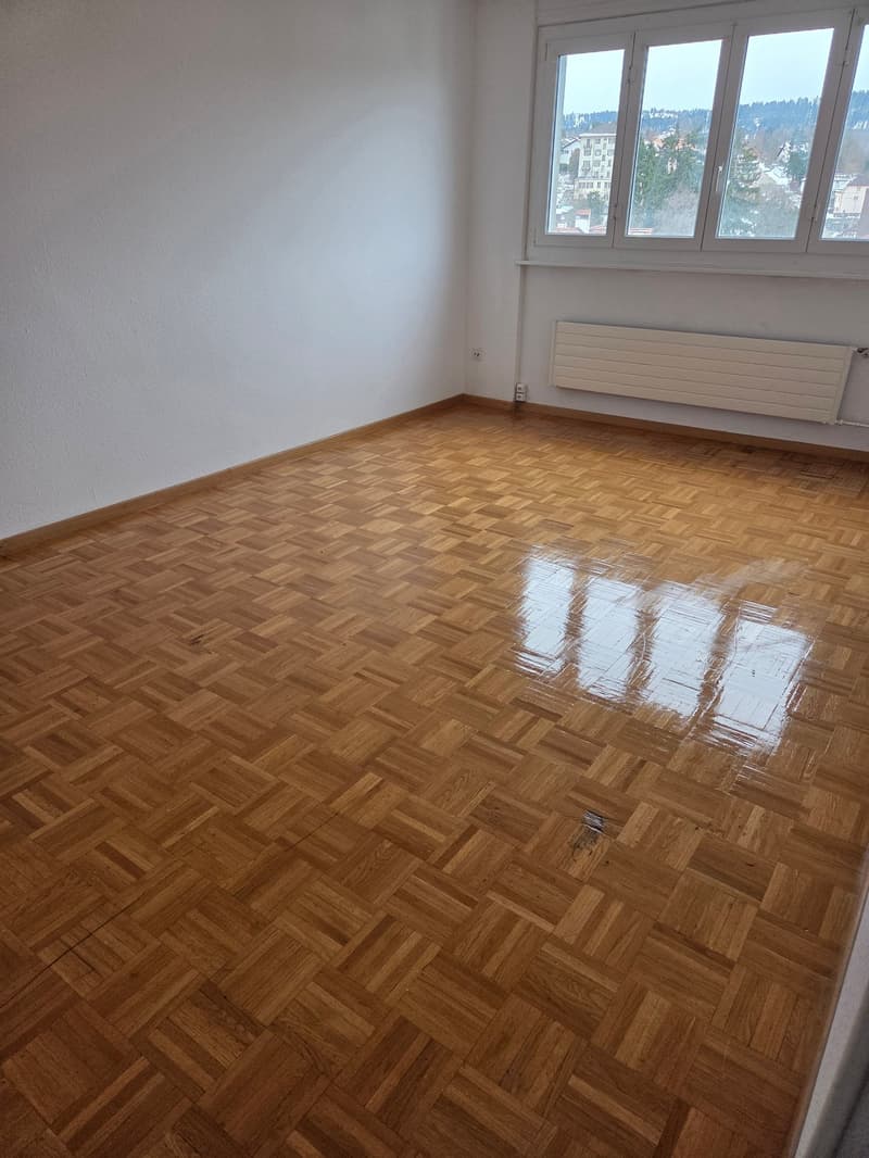 hardwood parquet flooring, large window, white walls, empty room
