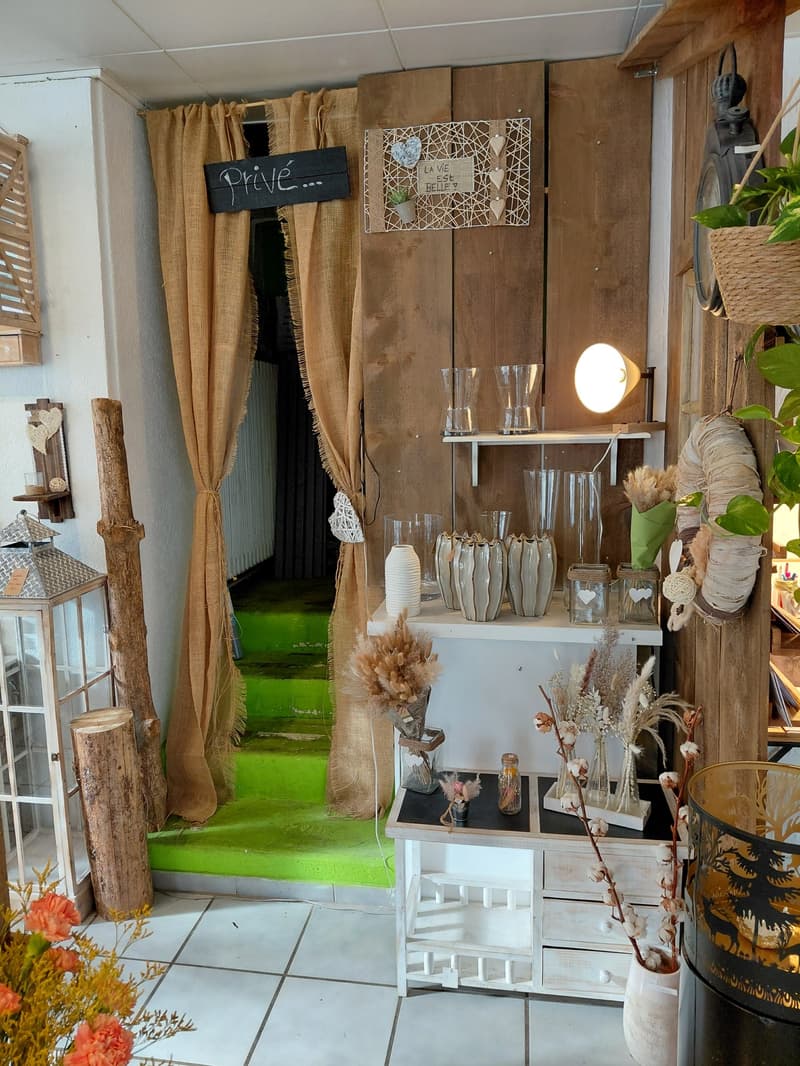 Staircase leading down, wooden door, burlap curtain, shelves with vases and decorative items